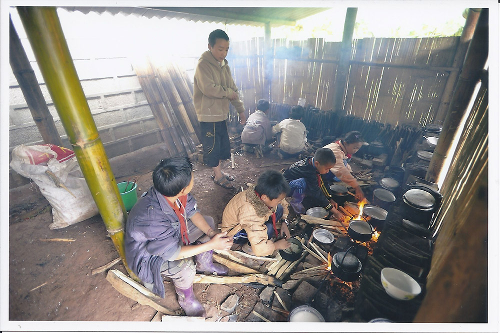 小朋友要自己煮飯，蹲在地上用磚砌成爐具。（圖：由受訪者提供）