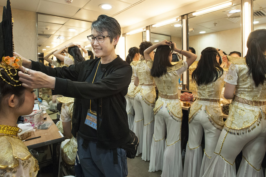 化妝間內，李老師細心地為舞蹈員整理頭飾（圖：Tim Liu）。