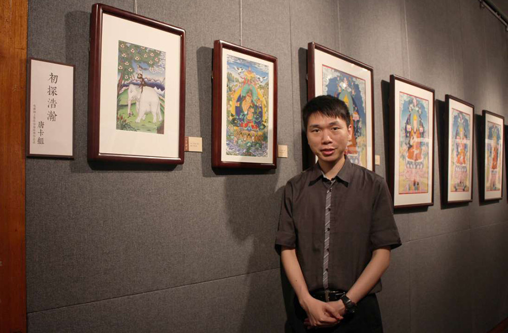 為周凱漩老師（Paris）。淨墨文化在香港大會堂舉行《以色觀法──彩繪佛畫交流展》，<br />
在「初探浩瀚」一欄展出多幅唐卡作品。Paris左首的兩幅唐卡，正出自他的手筆（圖：佛門網）